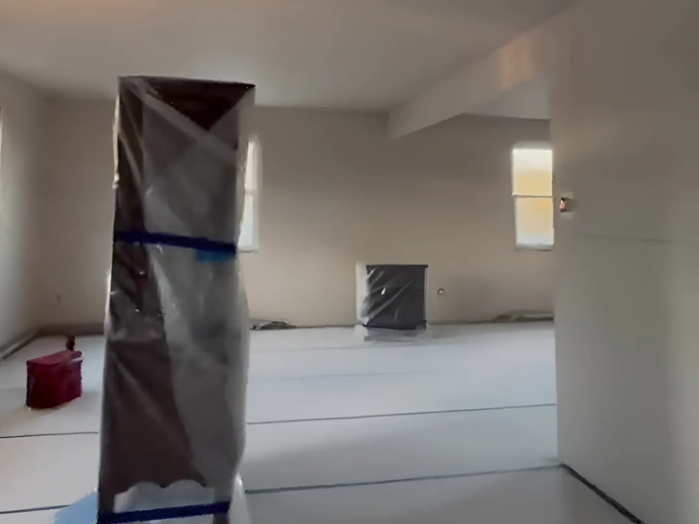 View of a room with custom metal framing elements wrapped and ready for precise installation.