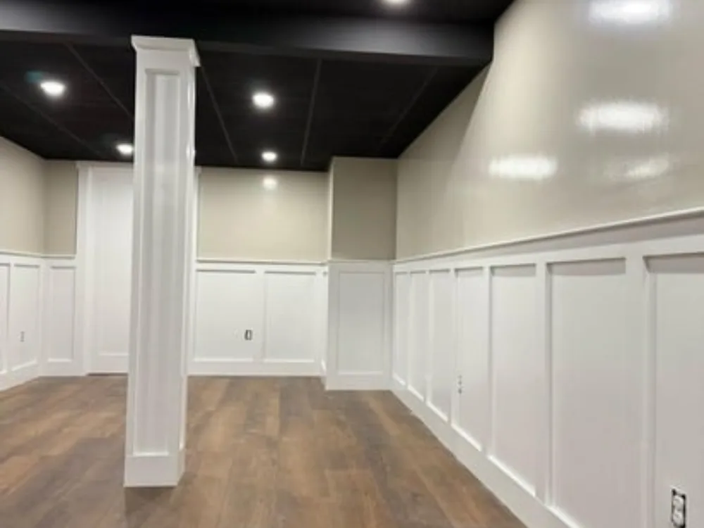 Small painting wall detail with white trim and wooden flooring in a modern interior.