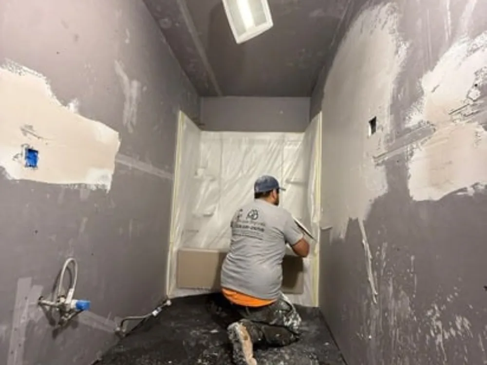 Drywall installation and finishing in progress for a bathroom.