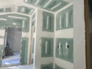 Drywall finishing with taped and sealed joints in a new room interior.