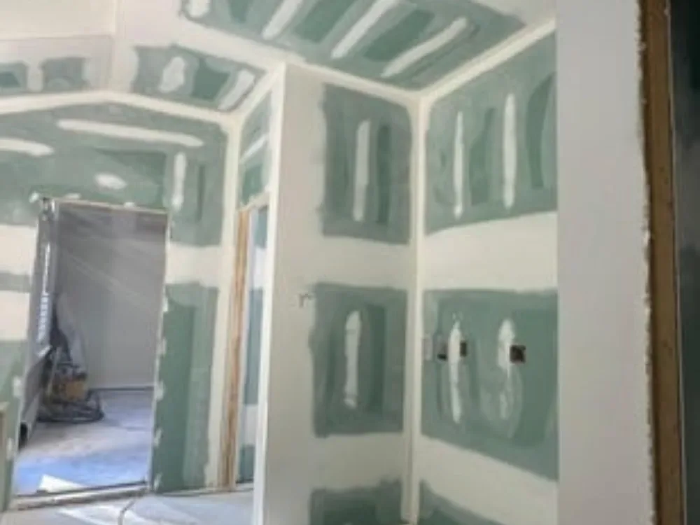Drywall finishing with taped and sealed joints in a new room interior.
