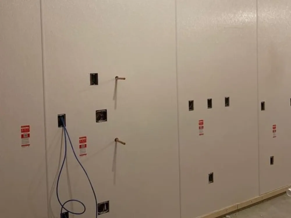 Wall utility installation with multiple electrical boxes and pipes.