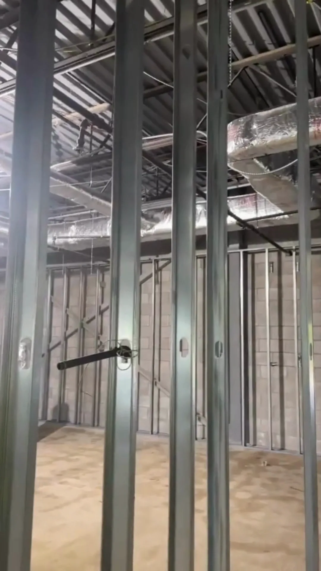 Metal stud framing installation showing aligned steel studs and conduits.