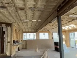 Insulation and drywall installation in framed living area.