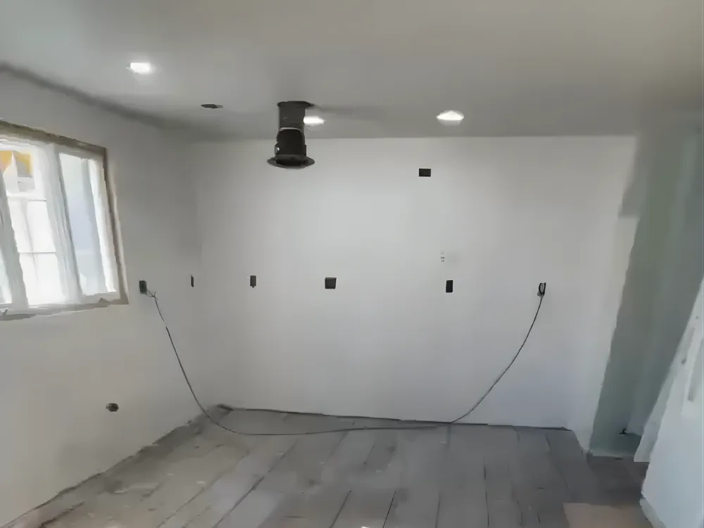 Kitchen renovation preparation with exposed subfloor and ceiling vent installation.
